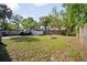 Fenced backyard with mature trees and space for outdoor activities, providing privacy at 216 W South Ave, Tampa, FL 33603