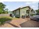 Backyard featuring a charming green house, a brick patio, and lush green grass at 216 W South Ave, Tampa, FL 33603