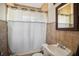 Tiled bathroom with a shower-tub combo and a window with natural light at 216 W South Ave, Tampa, FL 33603