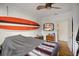 Cozy bedroom featuring a surfboard wall decoration, ceiling fan, and hardwood flooring at 216 W South Ave, Tampa, FL 33603