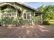 Side exterior view showcasing well-maintained green siding and brick foundation at 216 W South Ave, Tampa, FL 33603