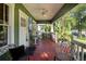 Inviting front porch featuring wood floors, ceiling fan, and outdoor seating, perfect for relaxing in the shade at 216 W South Ave, Tampa, FL 33603