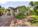 Charming green home with brick walkway, lush landscaping, and inviting curb appeal at 216 W South Ave, Tampa, FL 33603