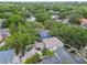 Aerial view of a blue home, with a pool and a screened lanai in a treed community at 2522 W Watrous Ave, Tampa, FL 33629