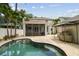 Lush backyard featuring a sparkling pool, screened lanai, and tropical landscaping for outdoor living at 2522 W Watrous Ave, Tampa, FL 33629