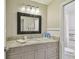 Bathroom with a granite vanity, light gray cabinets, and a black-framed mirror at 2522 W Watrous Ave, Tampa, FL 33629