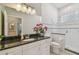 Well-lit bathroom with white cabinets, granite countertop, shower, and decorative accents at 2522 W Watrous Ave, Tampa, FL 33629