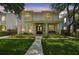Charming two-story home featuring a manicured lawn, lush landscaping, and a welcoming front porch with a bench at 2522 W Watrous Ave, Tampa, FL 33629