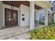 Inviting front porch featuring stone tiles, wooden support columns, and lush tropical landscaping at 2522 W Watrous Ave, Tampa, FL 33629