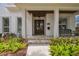 Close-up of the front porch with stone flooring, wood columns, a hanging lantern, and a bench at 2522 W Watrous Ave, Tampa, FL 33629