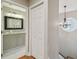 Hallway that leads into a bathroom with a granite vanity and light gray cabinets at 2522 W Watrous Ave, Tampa, FL 33629