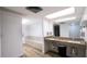Well lit bathroom with double vanity, bench, and wood look floors at 2616 Cove Cay Dr # 505, Clearwater, FL 33760