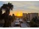 Beautiful sunrise view overlooking the covered parking, palm trees, and building at 2616 Cove Cay Dr # 505, Clearwater, FL 33760
