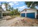 An exterior view of the home shows a paver patio, backyard, detached garage and lush trees at 310 N Lincoln Ave, Clearwater, FL 33755