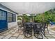 Outdoor patio with black table and chairs set with an awning, and lush green landscape at 310 N Lincoln Ave, Clearwater, FL 33755