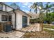 This backyard has a large patio, a dining set under an awning, and many plants and palm trees at 310 N Lincoln Ave, Clearwater, FL 33755