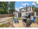 A cozy backyard with a patio dining set, chairs around a firepit, and trees in the background at 310 N Lincoln Ave, Clearwater, FL 33755