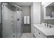 Modern bathroom with glass-enclosed shower, white vanity, and decorative white tile accent wall at 310 N Lincoln Ave, Clearwater, FL 33755