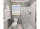 Well-lit bathroom featuring a glass shower, gray walls, a window, and a classic white toilet at 310 N Lincoln Ave, Clearwater, FL 33755