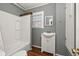 Bathroom featuring a toilet, tub and shower combination, sink, and window at 310 N Lincoln Ave, Clearwater, FL 33755