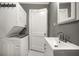 Gray bathroom featuring a stacked washer/dryer, a white door, hexagon tile floor, and a sleek sink at 310 N Lincoln Ave, Clearwater, FL 33755