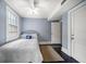Comfortable bedroom with hardwood floors, light blue walls, a white ceiling fan and bright natural light at 310 N Lincoln Ave, Clearwater, FL 33755