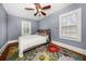 Bedroom featuring a ceiling fan, two windows, and a colorful floral rug at 310 N Lincoln Ave, Clearwater, FL 33755