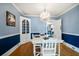 Charming dining room with chandelier, white table set, and light blue walls at 310 N Lincoln Ave, Clearwater, FL 33755