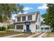 Charming two-story home boasts a blue door, gray shutters, and manicured landscaping at 310 N Lincoln Ave, Clearwater, FL 33755