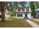 Attractive two-story home with a blue door, manicured landscaping, and classic architectural details at 310 N Lincoln Ave, Clearwater, FL 33755