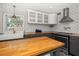 Modern kitchen with stainless steel hood, butcher block counters, and white subway tile backsplash at 310 N Lincoln Ave, Clearwater, FL 33755