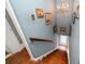 A unique staircase with wooden stairs, blue walls, and vintage decorations, bathed in natural light at 310 N Lincoln Ave, Clearwater, FL 33755