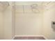 Walk in closet with installed wire rack shelving, wall-to-wall carpet, neutral walls, and base trim at 31215 Flannery Ct, Wesley Chapel, FL 33543