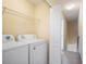 Bright laundry room with a washer, dryer, and shelving for easy storage, right by the staircase at 31215 Flannery Ct, Wesley Chapel, FL 33543