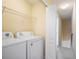 Bright laundry room with a washer, dryer, and shelving for easy storage, right by the staircase at 31215 Flannery Ct, Wesley Chapel, FL 33543