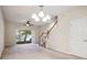 Spacious living room with natural light from the slider door, staircase, and fan for comfort at 31215 Flannery Ct, Wesley Chapel, FL 33543