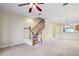 Open-concept living room with a staircase, neutral colors, and a seamless flow to the kitchen at 31215 Flannery Ct, Wesley Chapel, FL 33543
