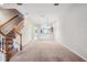 Bright living room featuring carpet floors, staircase, and access to the kitchen area, offering a cozy and inviting atmosphere at 31215 Flannery Ct, Wesley Chapel, FL 33543