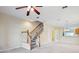 Spacious living room featuring a ceiling fan and staircase leading to the upper level at 31215 Flannery Ct, Wesley Chapel, FL 33543