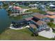An aerial shot of a canal front home with a pool enclosure, dock, solar panels, and mature palm trees at 3397 Bluefish Dr, Hernando Beach, FL 34607