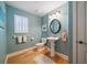 Cozy powder room with white fixtures, decorative mirror, and classic wood floors at 3397 Bluefish Dr, Hernando Beach, FL 34607