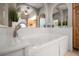 Soaking tub with jacuzzi jets, elegant arched mirrors, and views to adjoining bathroom and bedrooms at 3397 Bluefish Dr, Hernando Beach, FL 34607