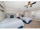 Bedroom featuring two twin beds with nautical-themed bedding, a ceiling fan, and plenty of natural light at 3397 Bluefish Dr, Hernando Beach, FL 34607