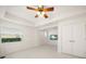 Bright bedroom featuring fresh white walls, ceiling fan, large windows, and tile floors at 3397 Bluefish Dr, Hernando Beach, FL 34607