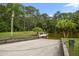 View of a public concrete boat ramp with a small dock surrounded by palm trees and a body of water at 3397 Bluefish Dr, Hernando Beach, FL 34607