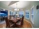 Light-filled dining room with wooden table set for six, plantation shutters, and wood floors at 3397 Bluefish Dr, Hernando Beach, FL 34607