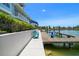 Waterfront home showcasing private dock with boat lift, colorful chairs, and manicured landscaping at 3397 Bluefish Dr, Hernando Beach, FL 34607