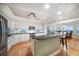 Open kitchen with white cabinets, island seating, stainless appliances and light hardwood floors at 3397 Bluefish Dr, Hernando Beach, FL 34607