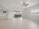 Bright living room with tile flooring, ceiling fan, and access to outdoor patio area at 3397 Bluefish Dr, Hernando Beach, FL 34607