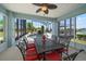 Screened patio with outdoor dining set overlooking pool with waterfall and peaceful waterfront view at 3397 Bluefish Dr, Hernando Beach, FL 34607